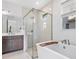 This modern bathroom features a soaking tub, glass-enclosed shower, and a double sink vanity with elegant fixtures at 16336 Preservation Blvd, Punta Gorda, FL 33982