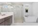 Bright bathroom features a soaking tub, glass enclosed shower, and modern vanity with elegant fixtures at 16336 Preservation Blvd, Punta Gorda, FL 33982