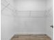 This walk-in closet has a simple rod and shelf system and tile flooring at 16336 Preservation Blvd, Punta Gorda, FL 33982
