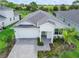 Aerial view of white home with a paver driveway and lush landscaping at 16336 Preservation Blvd, Punta Gorda, FL 33982