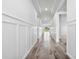 Bright hallway featuring modern wainscoting and flooring connecting rooms, offering seamless flow at 16336 Preservation Blvd, Punta Gorda, FL 33982
