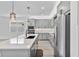 Well-lit kitchen with stainless steel appliances, grey cabinets, and a large quartz island at 16336 Preservation Blvd, Punta Gorda, FL 33982