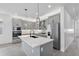 Sleek modern kitchen featuring gray cabinetry, stainless steel appliances, and a spacious island with quartz countertops at 16336 Preservation Blvd, Punta Gorda, FL 33982