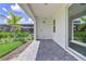 A covered patio has sleek brick flooring, a palm tree, and easy access to the screened-in pool area at 16336 Preservation Blvd, Punta Gorda, FL 33982