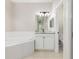 Bright bathroom features a soaking tub, double sink vanity with granite counters, and toilet room at 1693 Jagust Rd, North Port, FL 34288
