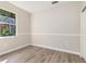 Bedroom with neutral walls, wood-look floors, one window, and bright natural light at 1693 Jagust Rd, North Port, FL 34288