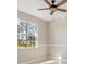 Bright bedroom with chair rail molding, a ceiling fan, and a window with a view at 1693 Jagust Rd, North Port, FL 34288
