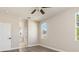 Light-filled bedroom with neutral walls, wood-look flooring, two windows, and access to a bathroom at 1693 Jagust Rd, North Port, FL 34288