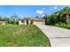 Charming single-story home featuring a two-car garage and a well-maintained lawn with tropical landscaping at 1693 Jagust Rd, North Port, FL 34288