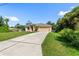 Well-kept home with a long driveway leading to an attached two-car garage and lush green lawn at 1693 Jagust Rd, North Port, FL 34288