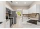 Galley kitchen with white cabinets, stainless steel appliances, and view into the adjacent dining area at 1693 Jagust Rd, North Port, FL 34288