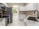 Modern kitchen featuring stainless steel appliances, granite countertops, and a tile backsplash at 1693 Jagust Rd, North Port, FL 34288