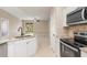 Open-concept kitchen area with stainless appliances, white cabinets, and an eat-in island at 1693 Jagust Rd, North Port, FL 34288