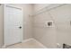 Tiled laundry room with metal storage rack and washer connections at 1693 Jagust Rd, North Port, FL 34288