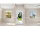 Bright living room with neutral walls, tile floor, and view of landscaped front yard at 1693 Jagust Rd, North Port, FL 34288