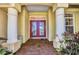 Elegant entrance showcasing stately columns, a red double door, and a brick pathway at 17188 Cape Horn Blvd, Punta Gorda, FL 33955