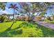 Inviting home with lush lawn, mature trees, colorful plants, and a brick driveway at 17188 Cape Horn Blvd, Punta Gorda, FL 33955