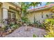 A cozy courtyard features a patterned brick patio surrounded by lush tropical landscaping and a bird bath at 17188 Cape Horn Blvd, Punta Gorda, FL 33955