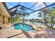 Sparkling pool boasts clear water, screened-in enclosure, brick patio, and tranquil lake views at 17188 Cape Horn Blvd, Punta Gorda, FL 33955
