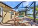 Sun-drenched pool deck featuring lounge chairs, a screened enclosure, and a serene lake view at 17188 Cape Horn Blvd, Punta Gorda, FL 33955