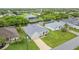 Aerial view of a single-Gathering home with a long driveway and a well-maintained lawn near a canal at 17200 Gulfspray Cir, Port Charlotte, FL 33948