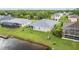 Aerial view of the home with its screened-in lanai, lush lawn and serene canal side yard at 17200 Gulfspray Cir, Port Charlotte, FL 33948