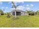 Lush backyard with palm trees and a well-maintained lawn, providing a serene outdoor living space at 17200 Gulfspray Cir, Port Charlotte, FL 33948