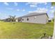 Wide backyard with palm trees and lush green lawn surrounds a house, creating a private outdoor oasis at 17200 Gulfspray Cir, Port Charlotte, FL 33948
