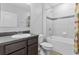 Well-lit bathroom featuring a tub with tiled walls, a shower, and a vanity with a dark countertop and wood cabinets at 17200 Gulfspray Cir, Port Charlotte, FL 33948