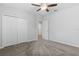 Spacious carpeted bedroom features a ceiling fan and a double-door closet with doorway to other rooms at 17200 Gulfspray Cir, Port Charlotte, FL 33948