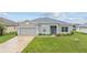 Well-maintained one-story home with a lush green lawn, gray exterior, and a two-car garage at 17200 Gulfspray Cir, Port Charlotte, FL 33948