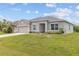 Well-maintained one-story home with a lush green lawn, gray exterior, and a two-car garage at 17200 Gulfspray Cir, Port Charlotte, FL 33948