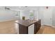 Kitchen island with a sink, dark cabinets, and stainless steel appliances at 17200 Gulfspray Cir, Port Charlotte, FL 33948