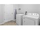 Functional laundry room equipped with a washer, a dryer, and an ironing board for household convenience at 17200 Gulfspray Cir, Port Charlotte, FL 33948