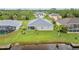 An aerial view of the rear of the home featuring a canal view, screened-in lanai, and well-maintained lawn at 17200 Gulfspray Cir, Port Charlotte, FL 33948