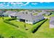 Aerial view of house with landscaped lawn and hedges, located in a sprawling residential community at 17336 Sandpearl Rd, Venice, FL 34293