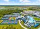 Community aerial shot showcasing tennis courts, pool, and ample parking surrounded by beautiful landscaping at 17336 Sandpearl Rd, Venice, FL 34293