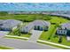 Aerial view of a home with a large lawn, lush landscaping, and inviting curb appeal at 17336 Sandpearl Rd, Venice, FL 34293