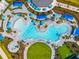 Bird's eye of a uniquely shaped swimming pool with sun loungers and tables, surrounded by lush landscaping and lawns at 17336 Sandpearl Rd, Venice, FL 34293