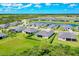Aerial view of homes surrounding lake and golf course in Wellen Park community with lush green landscaping at 17336 Sandpearl Rd, Venice, FL 34293