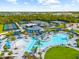 Aerial view of community pool, tennis courts, and clubhouse in lush landscaping at 17336 Sandpearl Rd, Venice, FL 34293