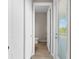 Hallway leading to a well-lit half bathroom with luxury vinyl tile flooring at 17336 Sandpearl Rd, Venice, FL 34293