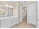 Bright bathroom with double sinks, white cabinets, and access to other rooms at 17336 Sandpearl Rd, Venice, FL 34293