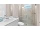 This neutral bathroom features a walk-in shower, white vanity, and decorative accent pieces at 17336 Sandpearl Rd, Venice, FL 34293