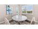 Cozy dining area features a modern round table and plantation shutters at 17336 Sandpearl Rd, Venice, FL 34293