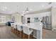 Kitchen features stainless steel appliances, stylish backsplash, white cabinets, long island and open floor plan into living room at 17336 Sandpearl Rd, Venice, FL 34293