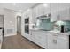 Bright kitchen features stainless steel appliances, stylish backsplash, and white cabinets with bar access to another room at 17336 Sandpearl Rd, Venice, FL 34293
