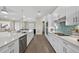 Modern kitchen features stainless steel appliances, stylish backsplash, and white cabinets with long island and open floor plan at 17336 Sandpearl Rd, Venice, FL 34293