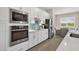 Modern kitchen features stainless steel appliances, stylish backsplash, white cabinets, and breakfast nook with bright natural light at 17336 Sandpearl Rd, Venice, FL 34293