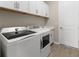 Convenient laundry room featuring modern washer and dryer and ample storage space at 17336 Sandpearl Rd, Venice, FL 34293